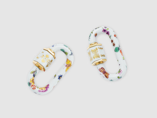 Zwei Porzellan-Schlösser mit violett-roten Blüten, Schmetterlings- und Beerenmotiven; feine Goldornamente auf der Hülse.
Two porcelain locks with purple-red blossoms, butterfly and berry motifs; delicate gold ornament on the sleeve.