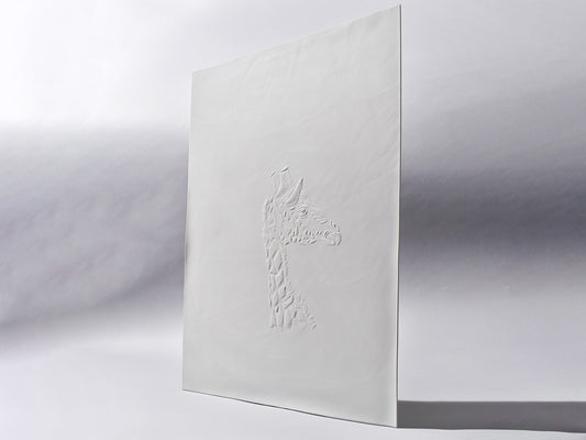 Aufrecht stehende Biskuitporzellanfliese in Weiß mit einem plastisch ausgearbeiteten Giraffenkopf im Profil. Die matte Oberfläche unterstreicht die feine Reliefstruktur.