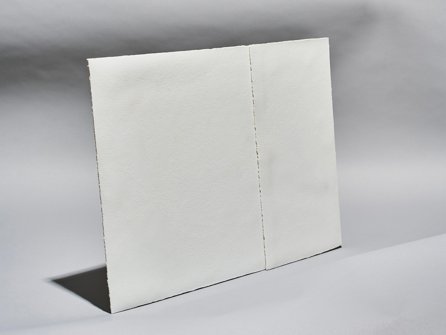 Zwei unglasierte weiße Porzellanfliesen der Serie Lightscape, nebeneinander aufgestellt, mit feiner, matter Oberfläche.

Two unglazed white porcelain tiles from the Lightscape series, standing side by side, featuring a fine, matte surface.