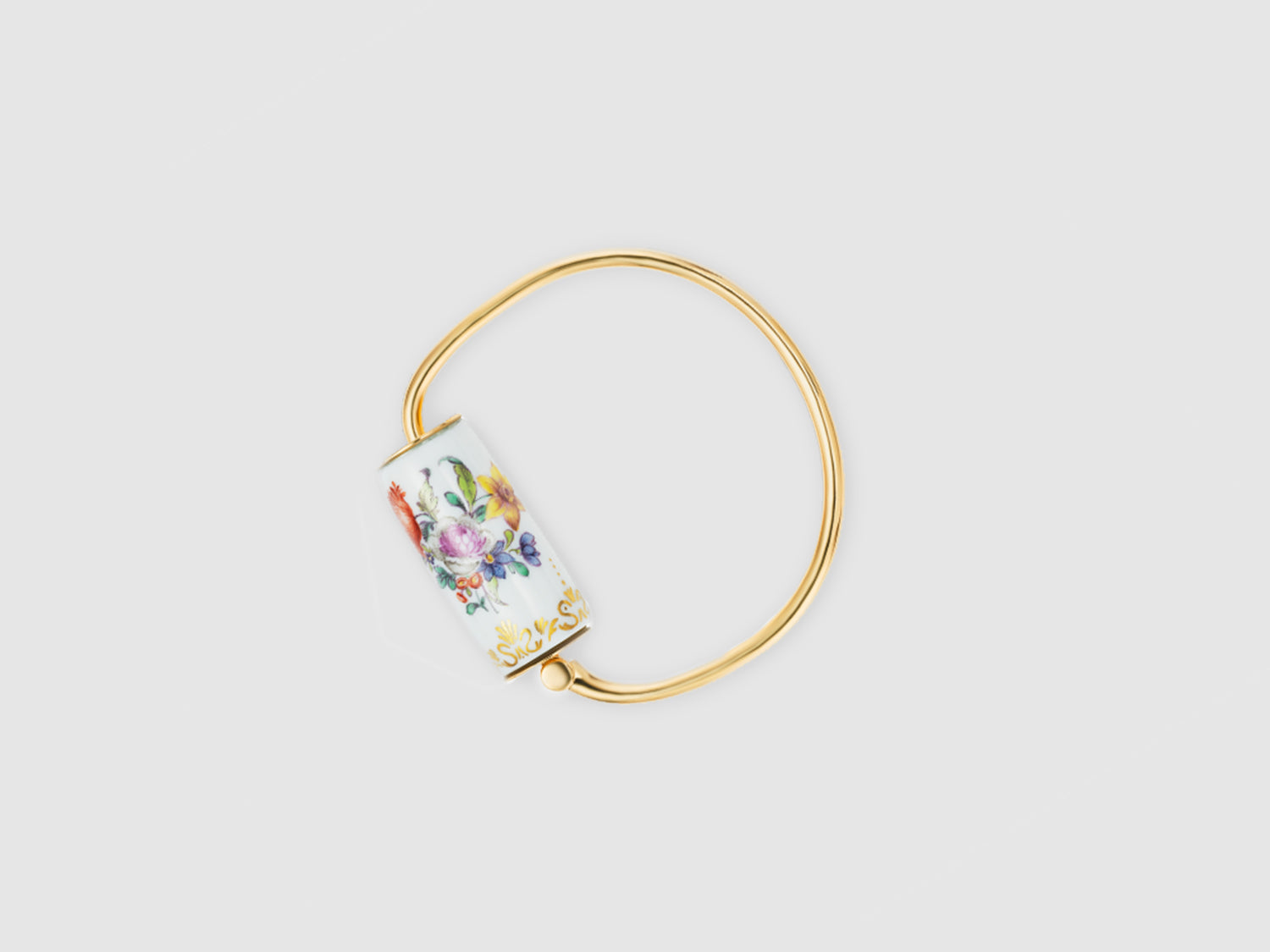 Alt (DE): Goldfarbener Armreif mit zylindernem Porzellan-Element, handbemalt mit buntem Blumenbouquet auf weißem Grund.

Gold-toned bangle with a cylindrical porcelain element, hand-painted with a colorful floral bouquet on white.