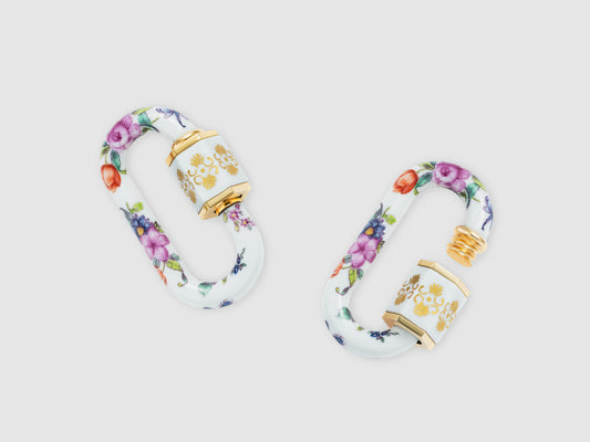 Porzellan-Schlösser mit handbemaltem Blumenmuster, hexagonaler Hülse und goldfarbenen Details, Draufsicht.

Pair of porcelain locks with hand-painted floral pattern, hexagonal sleeve and gold-tone accents, top view.