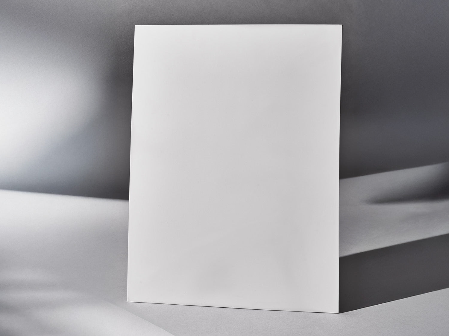 Biskuitfliese stehend vor grauem Hintergrund, frontal aufgenommen.

Biscuit tile standing upright against grey background, front view.