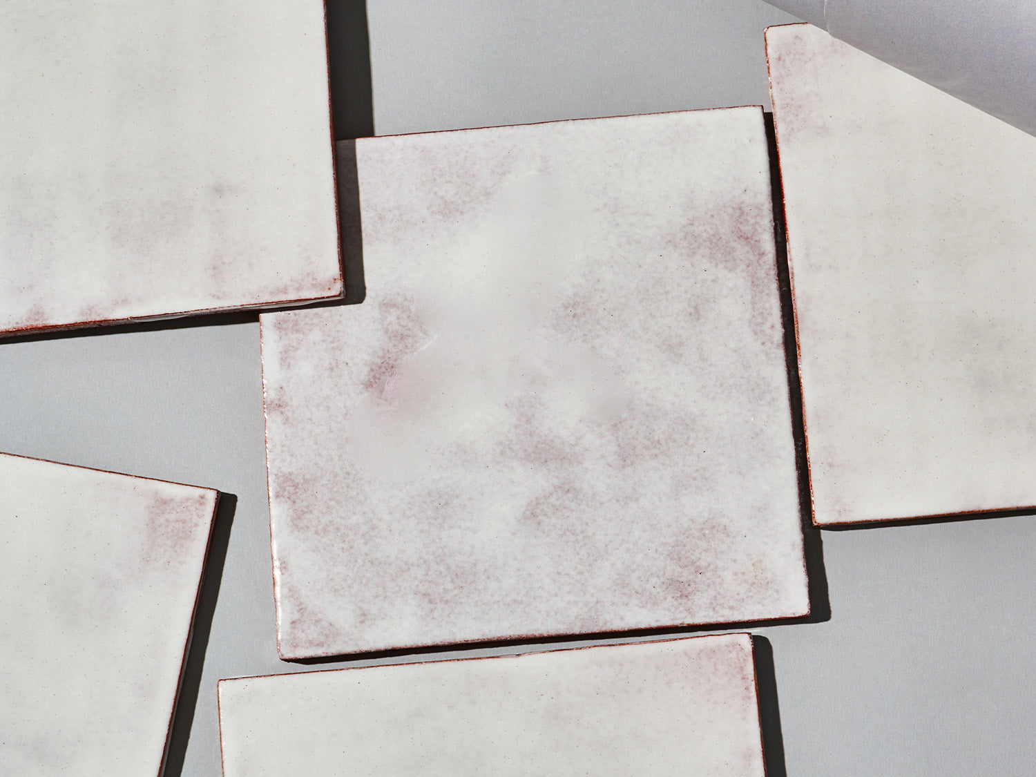 Majolika-Fliese mit durchschimmernder weißer Glasur und changierender Oberfläche.

Majolica tile with translucent white glaze and subtly shifting surface tones